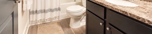 A bathroom with a toilet, sink, and shower.