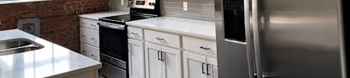 A modern kitchen with stainless steel appliances and white cabinets.