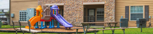 A playground with a slide and a purple slide.