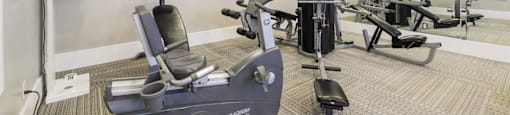 A gym with a rowing machine in the foreground.