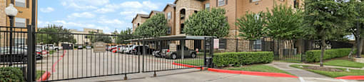 A gated parking lot in front of a building.