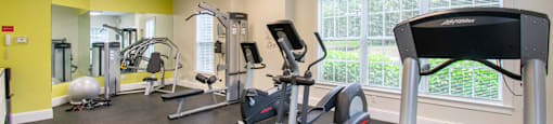 Fitness center with cardio and weight equipment at Woodlands at Abington Station Apartments, Massachusetts