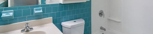A white toilet sits next to a sink in a bathroom at Edmands House, Massachusetts, 01701