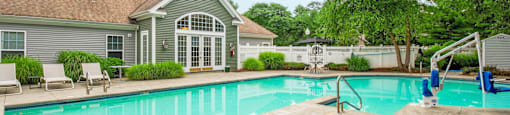 Swimming pool with clubhouse and sundeck at Woodlands at Abington Station Apartments, Abington, MA