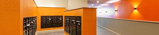 a large wine cellar with orange walls and rows of wine bottles at Beverly Village for Living & the Arts Apartments, Beverly, 01915
