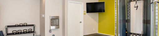 Community Fitness Center with weights and a tv on the wall at Station Pointe Apartments, Mansfield, MA, 02048