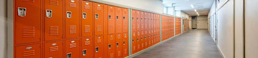 a row of orange lockers in a hallway in a building at Beverly Village for Living & the Arts Apartments, Beverly, 01915