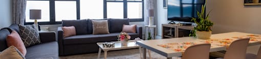 a living room with a tv and a table and chairs at Dorado Apartments, Yonkers, New York