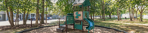 Playground with slide in park area at Woodlands at Abington Station Apartments, Massachusetts