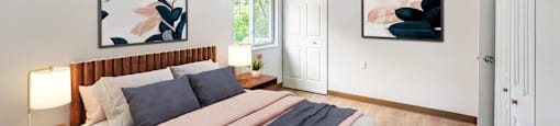 a bedroom with a bed and two paintings on the wall