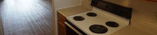 an empty kitchen with a stove and cabinets and a sliding glass door