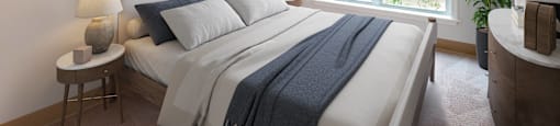 Modern bedroom with neutral decor at Woodlands at Abington Station Apartments, Massachusetts