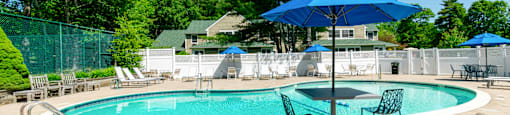 A blue umbrella is next to a pool table at at Mariner's Hill Apartments, Massachusetts.