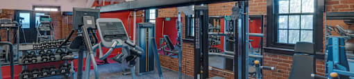 a gym with weights and cardio equipment and a brick wall at Ninth Square Apartments, Connecticut, 06510