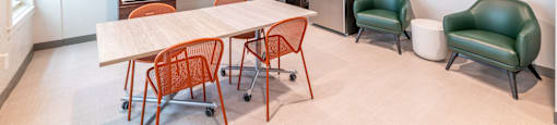 a dining room with a table and chairs and a kitchen with a refrigerator at 140 Clarendon, Boston MA.