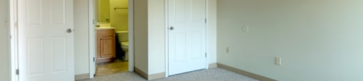 Carpeted Bedroom With Attached Bath at Pondside at Littleton Apartments. at Pondside at Littleton, Littleton, 01460