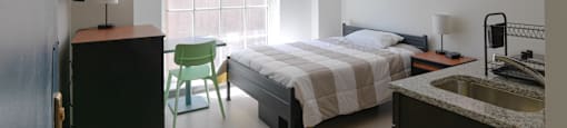 a bedroom with a bed and a sink and a chair  at 140 Clarendon, Boston, MA, 02116