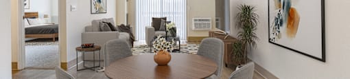 A living room of an apartment with a table and chairs at North Stoughton Village Apartments in Stoughton, MA