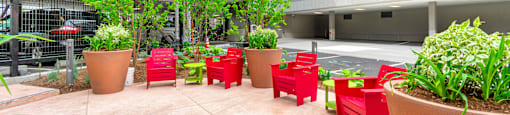 A courtyard with red chairs and plants.