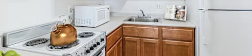 a kitchen with white appliances and wooden cabinets at Montani Towers, Wheeling West Virginia