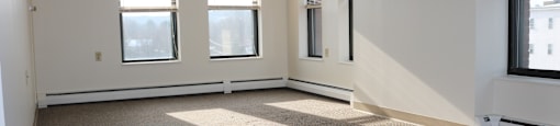 Living Room With Large Windows and Carpet at Pequoig House in Athol, MA.
