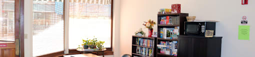 Community Room With Table and Seating at Pequoig House in Athol, MA.