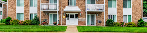 an apartment building with a sidewalk and grassat North Stoughton Village, Stoughton, Massachusetts