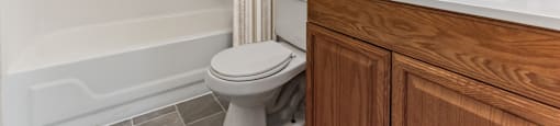 a bathroom with a toilet and a sink and a shower at Dillsburg Heights Apartments, Dillsburg, PA