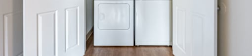 A white laundry room with a washer and dryer.