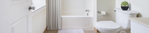 A white bathroom with a toilet, sink, and bathtub.