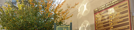 a sign for the times village on the side of a building at Tai Tung Village, Boston, MA