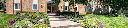 a walkway in front of a brick apartment building