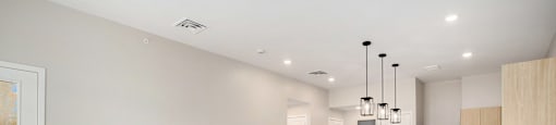 A spacious kitchen with wooden floors and a ceiling fan.