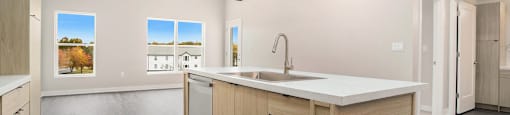 A modern kitchen with wooden cabinets and a white countertop.