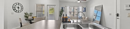 A modern kitchen with a granite countertop and a black dishwasher.