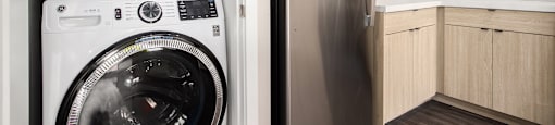 A modern kitchen with a washing machine and refrigerator.