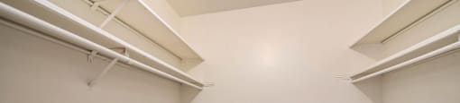 an empty room with white walls and two shelves on the wall