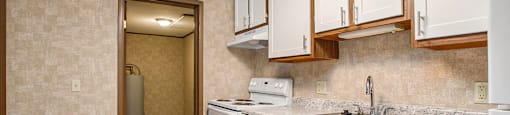 a kitchen with white cabinets and a white dishwasher