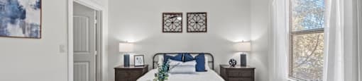 A bedroom with a bed, nightstands, and a ceiling fan.