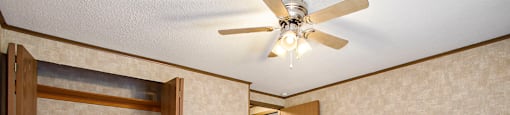 a bedroom with a ceiling fan and a door to a bathroom