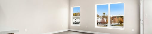 Empty room with a ceiling fan and three pictures on the wall.