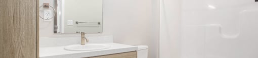 A white toilet sits next to a sink in a modern bathroom.
