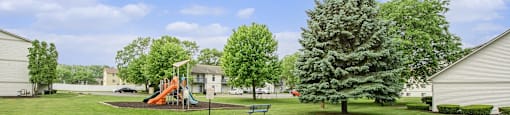 a backyard with a swing set and a tree