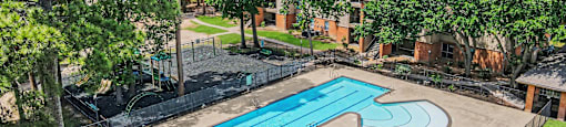 A swimming pool surrounded by a fence and trees.