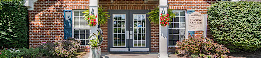 the front of a brick building with two doors and a porch