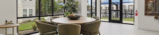 A dining room with a table and chairs.