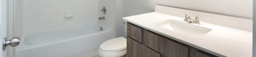 A white bathroom with a toilet, sink, and shower.