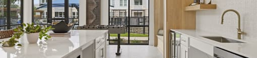 A modern kitchen with white countertops and stainless steel appliances.