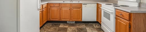 a kitchen with wooden cabinets and white appliances