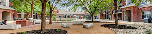 A tree-lined walkway leads to a building.